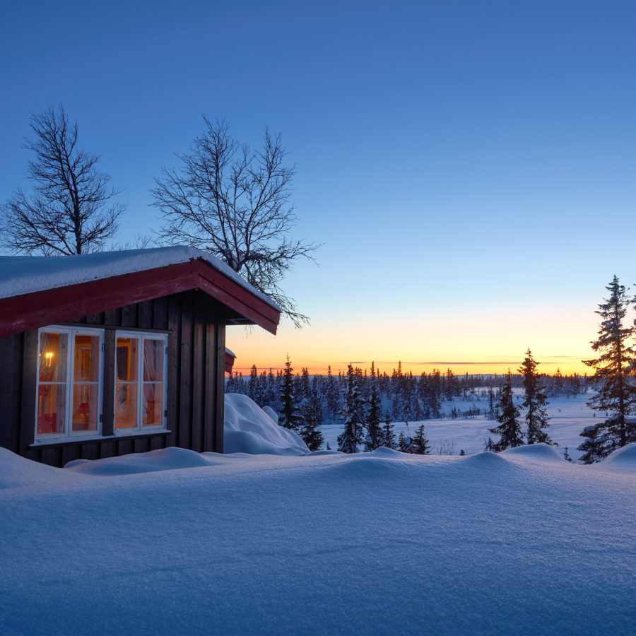 Norsk hytte dekket i snø om vinteren